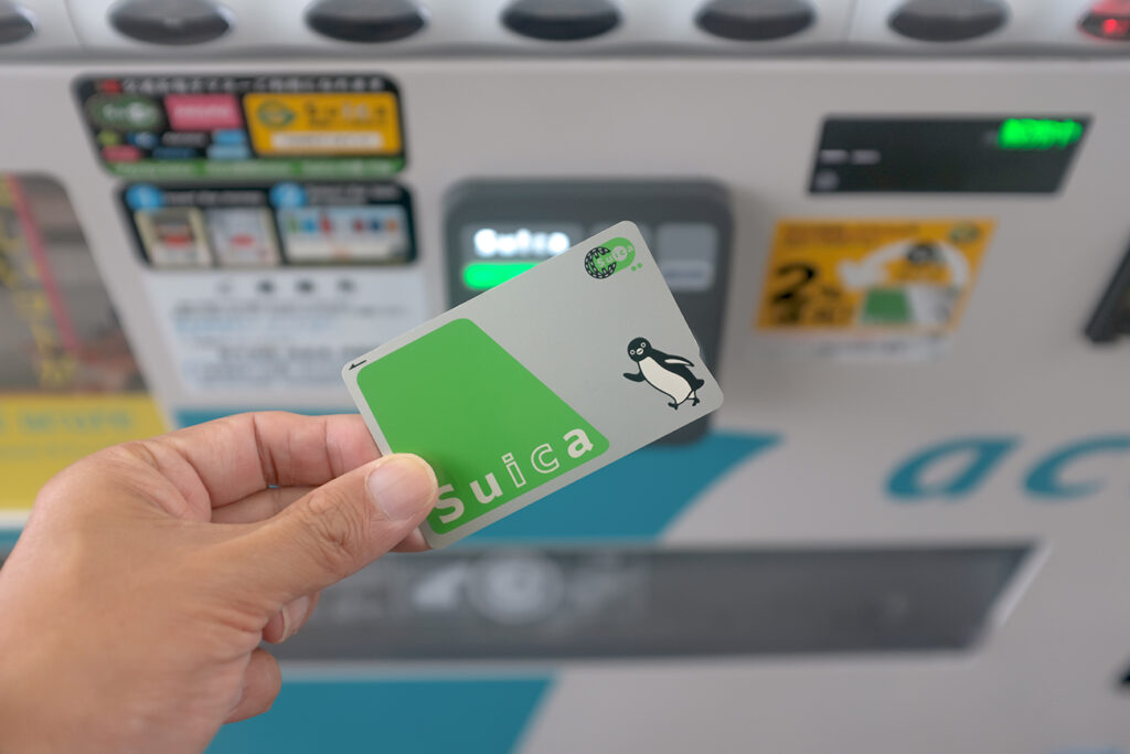 Close up view of a customer using a Suica prepaid e-money card to buy drinks from a vending machine at Sapporo Station